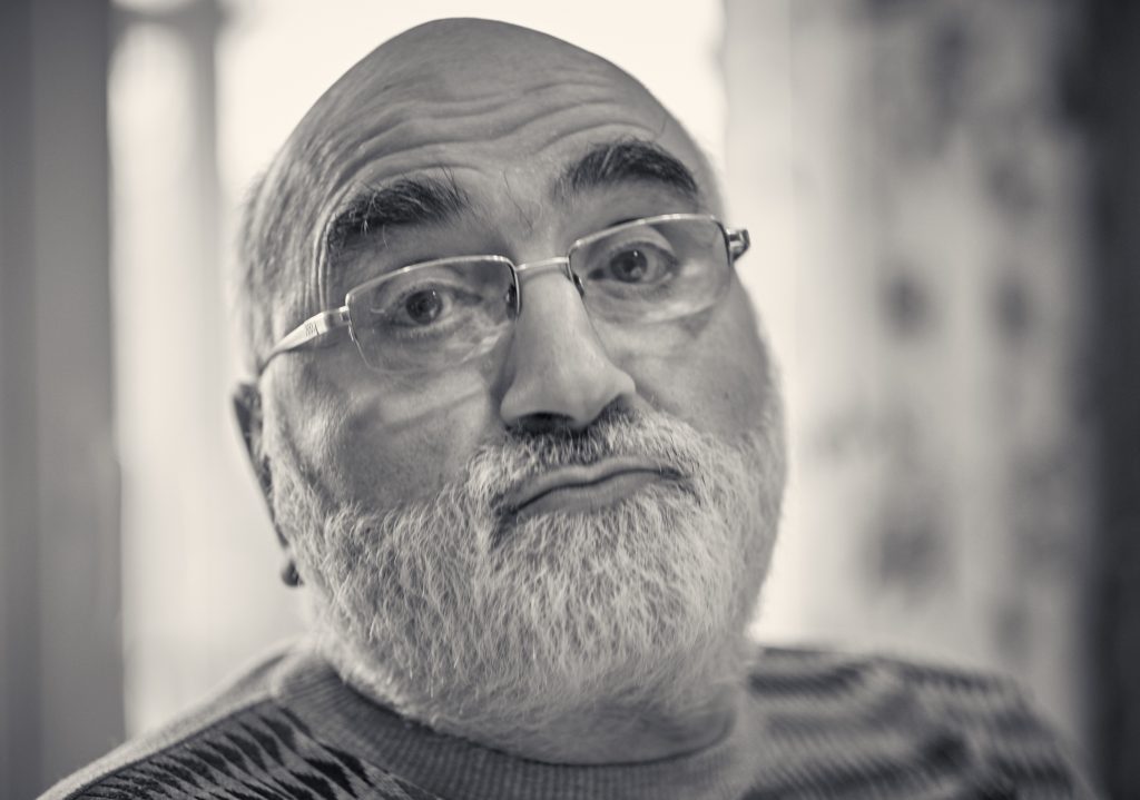 Black and white portrait of elderly man with glasses and beard in thoughtful pose - © Pascal Recchia. All rights reserved.