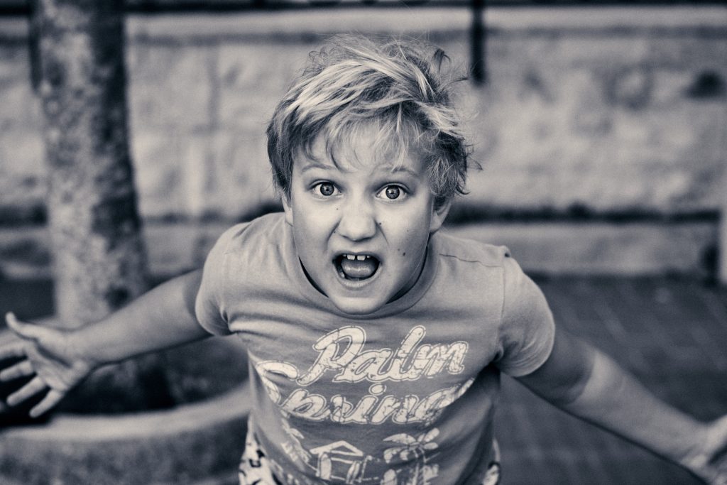 Black and white photo of excited child wearing Palm Beach t-shirt, mouth open - © Pascal Recchia. All rights reserved.