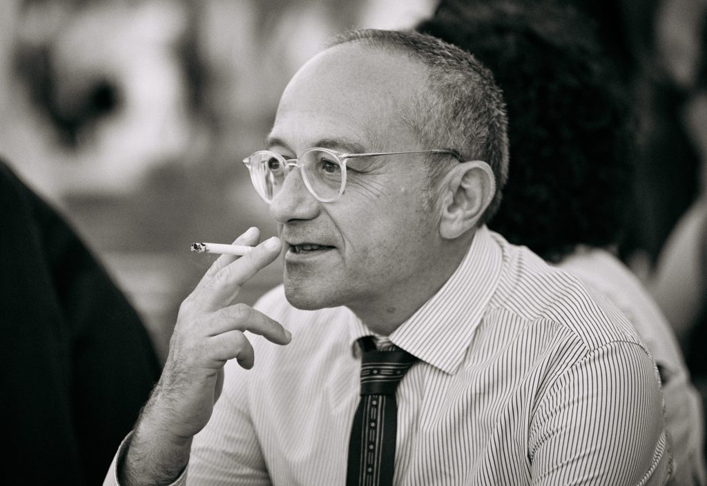 Black and white portrait of elderly man with glasses and striped shirt smoking - © Pascal Recchia. All rights reserved.