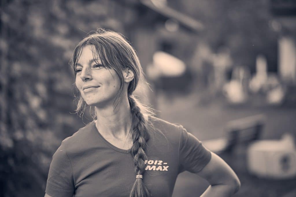 Woman with braided hair smiling outdoors in sepia-toned athletic portrait - © Pascal Recchia. All rights reserved.