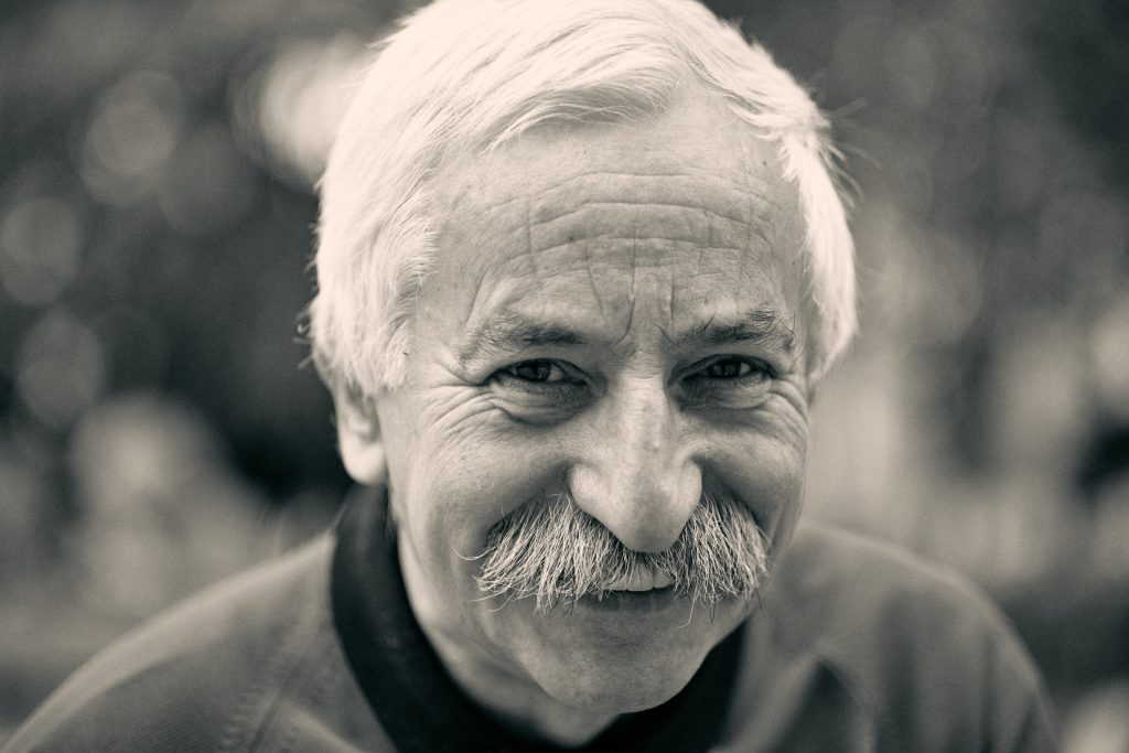 Black and white portrait of smiling elderly man with white mustache and wrinkled face showing warmth and character - © Pascal Recchia. All rights reserved.