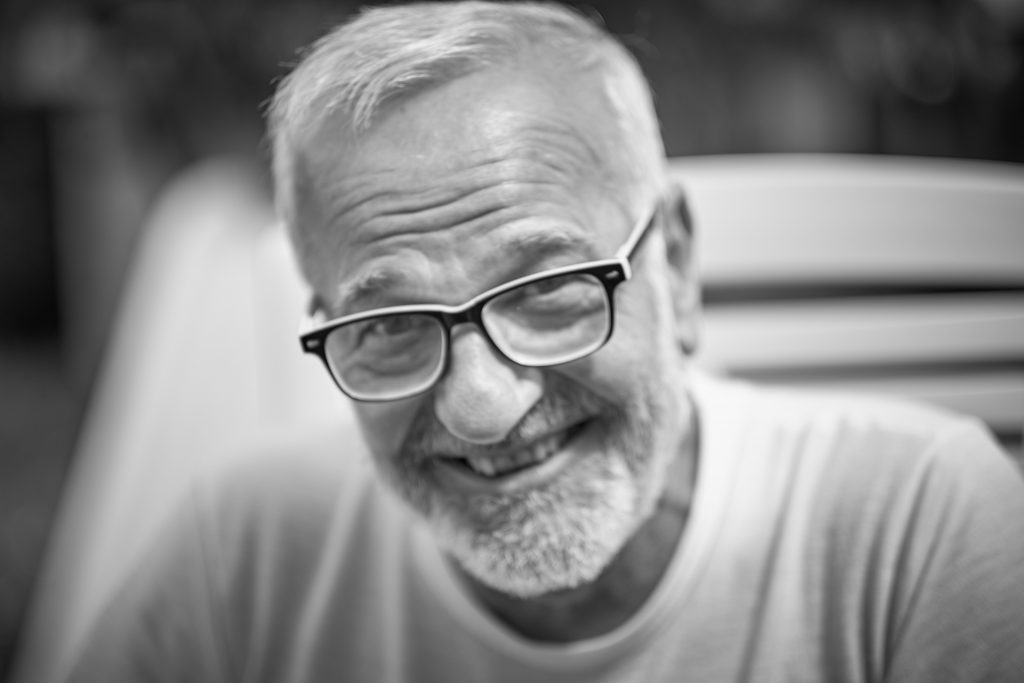 Smiling elderly man with glasses and gray beard in black and white photo - © Pascal Recchia. All rights reserved.