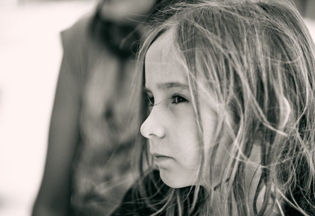 Black and white portrait of girl with long blonde hair looking pensively to the side in soft natural lighting - © Pascal Recchia. All rights reserved.