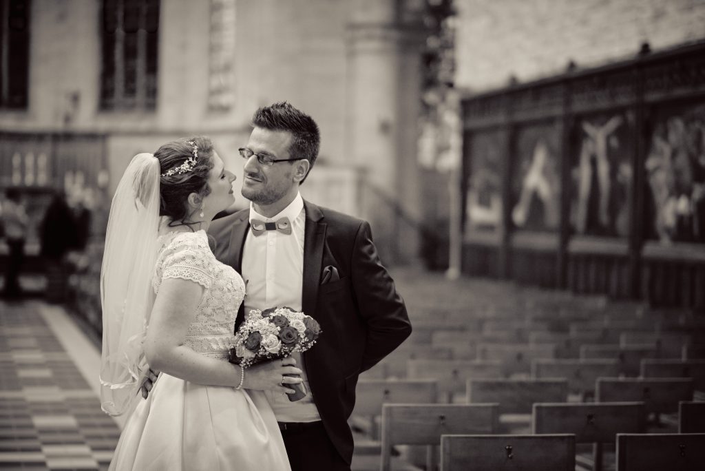 Bride and groom in vintage sepia wedding portrait, standing on stone steps in romantic embrace with bouquet - © Pascal Recchia. All rights reserved.