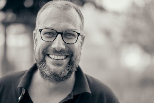 Professional headshot of smiling man with glasses and beard in black and white, shot with shallow depth of field - © Pascal Recchia. All rights reserved.